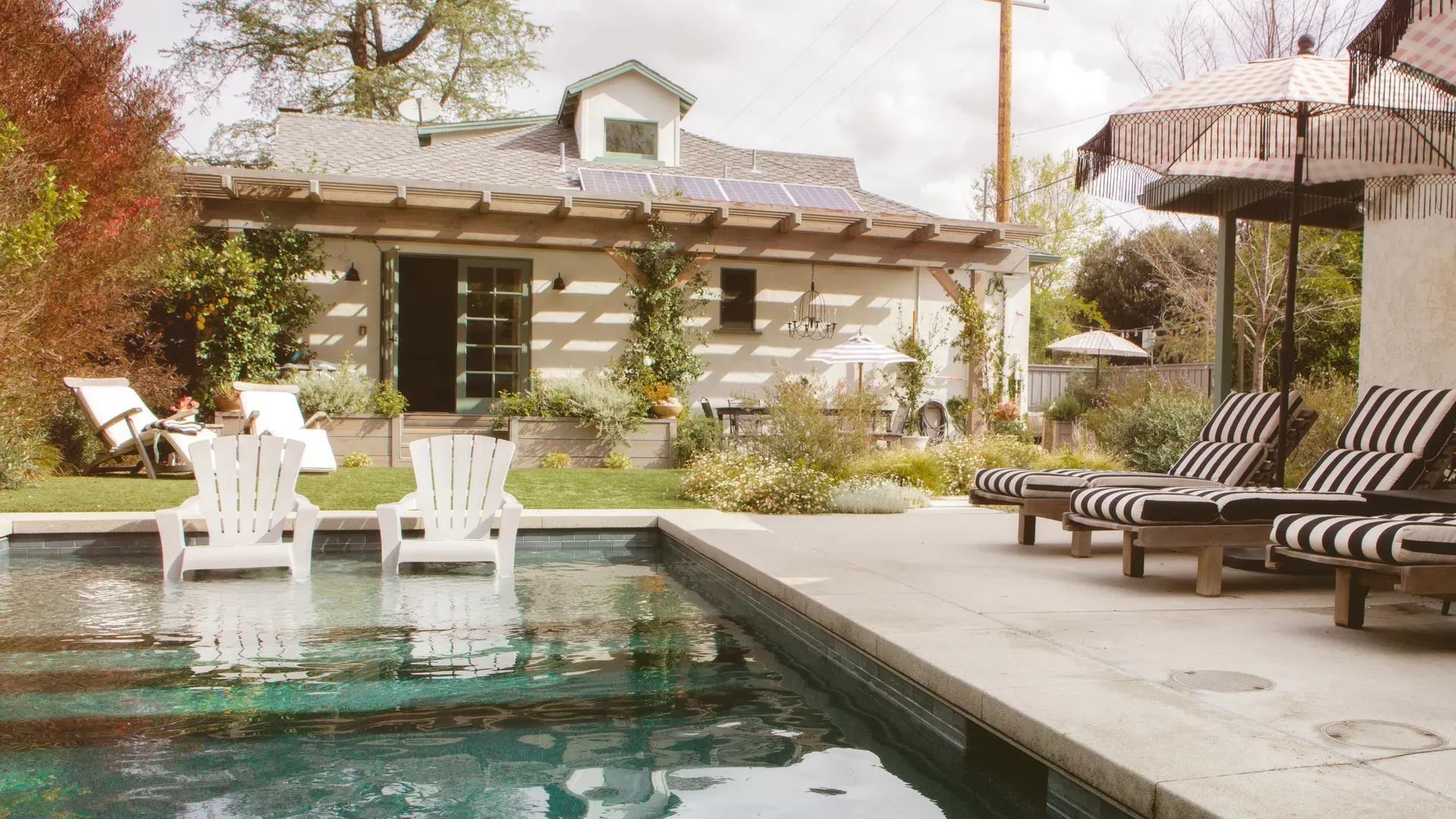 An outdoor living room in Holmby Hills, stone and timber above the pool
