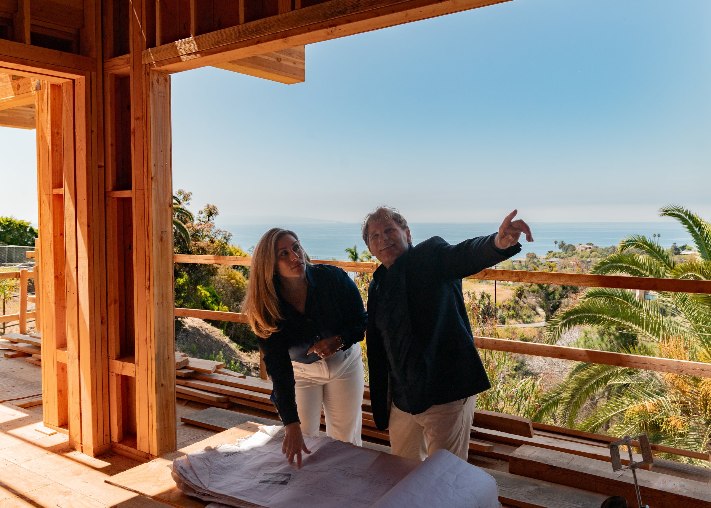 Mike Ross pointing out the view to Christine Ross from a hillside site above the coast